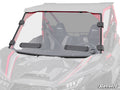 A Kawasaki Teryx KRX 1000 Vented Full Windshield with two black wiper blades and four side clamps is mounted on a red off-road utility vehicle. A circular vent is on the passenger side, with bucket seats inside and a SuperATV logo in the corner.