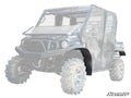 A black Kawasaki Mule Pro Low Profile Fender Flare is featured on the front driver’s side wheel of a partially transparent off-road utility vehicle, with the “SuperATV” logo in the bottom right corner.