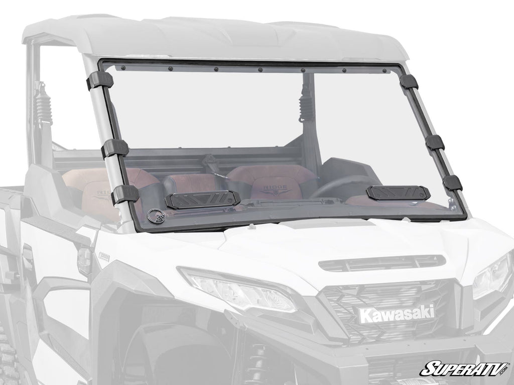 A Kawasaki Ridge Vented Full Windshield with two vents and black clamps is installed on a white Kawasaki utility vehicle. The background and vehicle are faded to highlight the windshield, with the SuperATV logo in the bottom right corner.