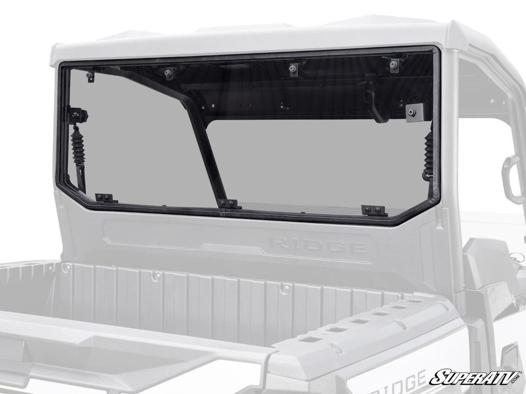 A Kawasaki Ridge Rear Windshield with a black frame is installed on a UTV, secured by six top bolts and supported by side gas struts. Both the vehicle and windshield feature RIDGE and SuperATV branding.