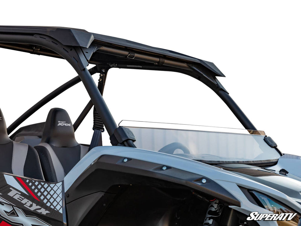 A close-up of a Kawasaki Teryx KRX 1000 featuring a half windshield and roll cage, two seats, “Teryx” branding on the side, set against a white background with the SuperATV logo in the lower right corner.