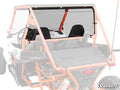 A rear view of an orange off-road utility vehicle equipped with the Kayo S200 Rear Windshield. Two black seats, a dashboard with controls, and a roll cage are visible. The SuperATV logo appears in the bottom right corner.