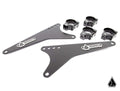 The Assault Industries Extended Light Bar Bracket Kit (Universal) includes two black triangular metal plates with multiple holes, four clamp mounts, and sleek matte finishes. Components feature the Assault logo on metal badges and a small triangular logo 
