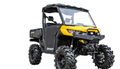 A Can-Am Defender with a 6 Lift Kit, featuring rugged off-road tires, high ground clearance, a front winch, protective roof, doors, windscreen, and cargo bed in yellow/black is shown on a white background.