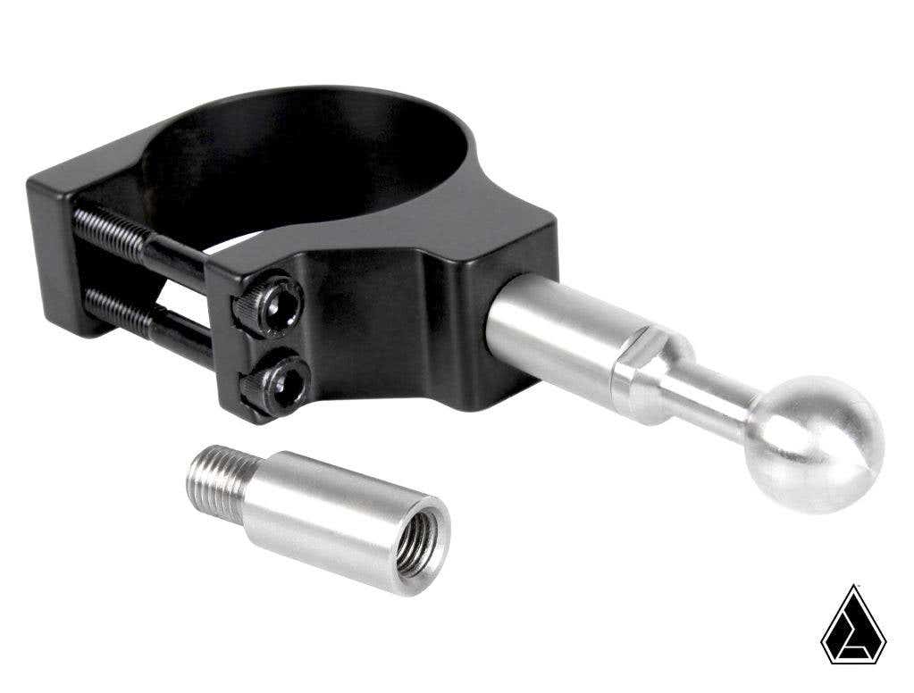 The Assault Industries M10 to M10 Mirror Post Extension features a black clamp with two visible screws attached to a silver rod ending in a round ball, next to a small silver threaded adapter. A black geometric logo appears in the bottom right on a white 