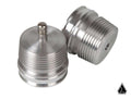 Two silver, cylindrical Assault Industries Shock Reservoir Nitrogen Expansion Caps (for Fox Shocks) are shown—one upright with a top knob, one on its side revealing an end hole. A small black triangular logo appears at the bottom right.