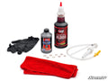 The Portal Gear Lift Install Kit includes black gloves, a small brake fluid bottle, a large Portal Blood bottle, eight copper washers, a hand pump with tubing, and two red microfiber cloths. SuperATV logo appears in the bottom right corner.