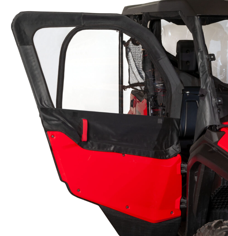 A close-up of the Framed 1/2 Upper Door Kit – Honda Pioneer 1000 shows the red and black off-road vehicle with a partially open soft door, featuring a clear plastic window, black fabric border, and a mesh storage pouch behind the seat.