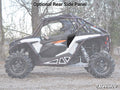 A side view of a Polaris RZR XP Turbo S with rugged tires, roll cage, and helmeted driver displays “Optional Rear Side Panel” above. Trees and dry ground appear in the background, with the SuperATV logo at bottom right. Lower Doors are featured.