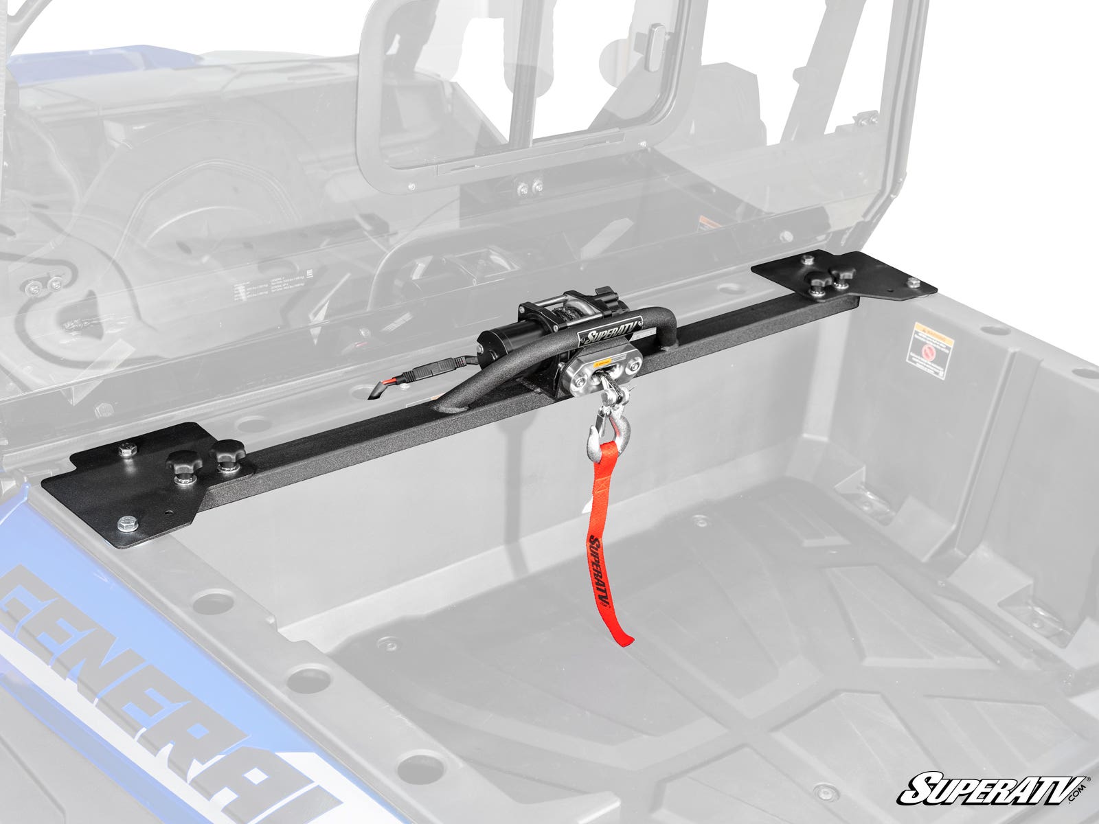 A Polaris General XP 1000 Bed Winch with a red pull strap is mounted between sturdy plates on a horizontal bar in the cargo bed of a Polaris General, with the SuperATV logo visible in the bottom right corner.