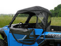 A blue off-road vehicle with a Polaris General Full Cab Enclosure for an existing hard windshield, featuring a black soft cab with zippered windows and doors, is parked on grass with trees in the background under an overcast sky.