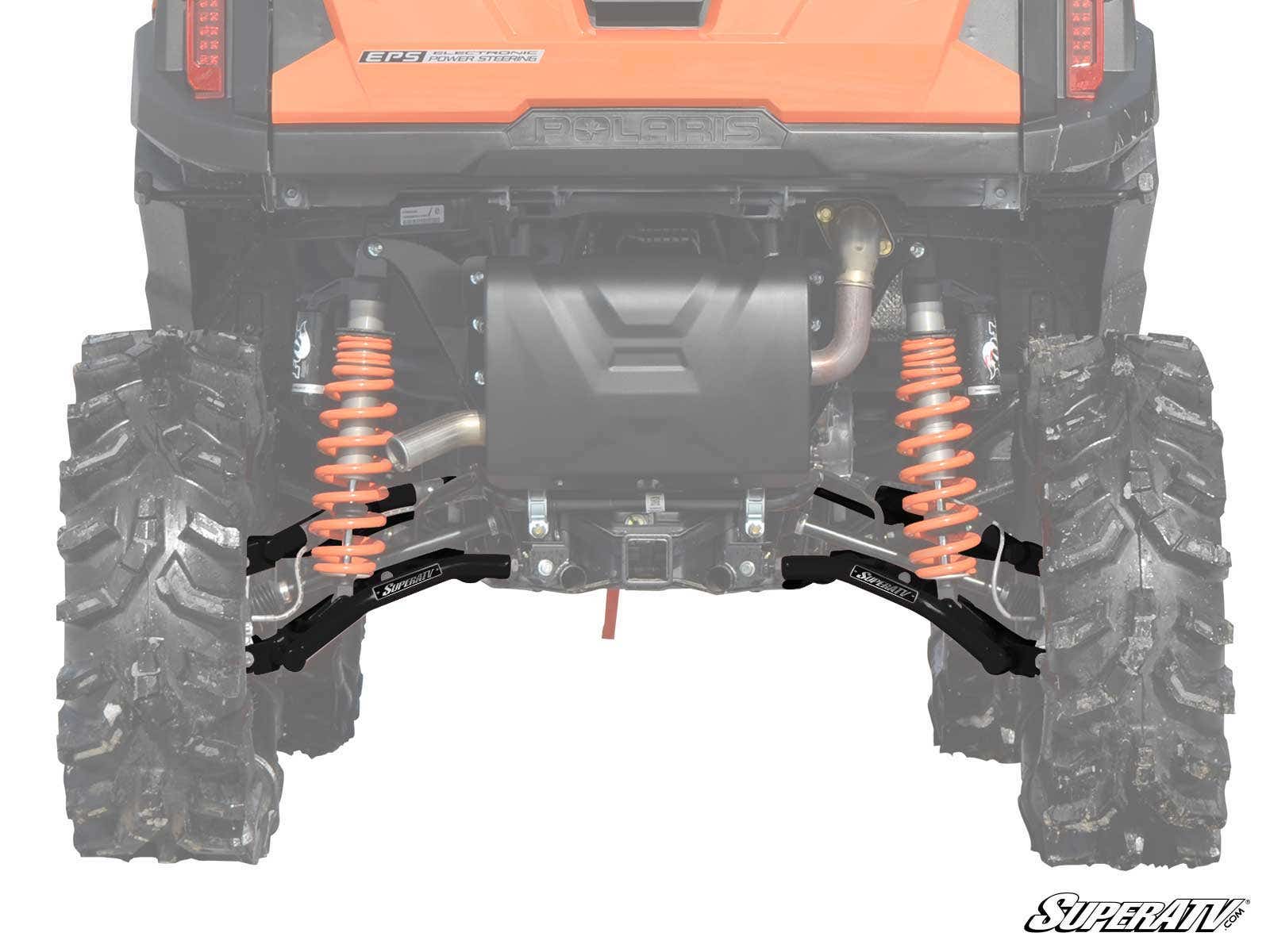 Rear view of a Polaris RZR Trail S 900 featuring large tires and orange springs. Black High Clearance 1.5 Rear Offset A-Arms from SuperATV are highlighted beneath the orange body, with the SuperATV logo in the bottom right corner.