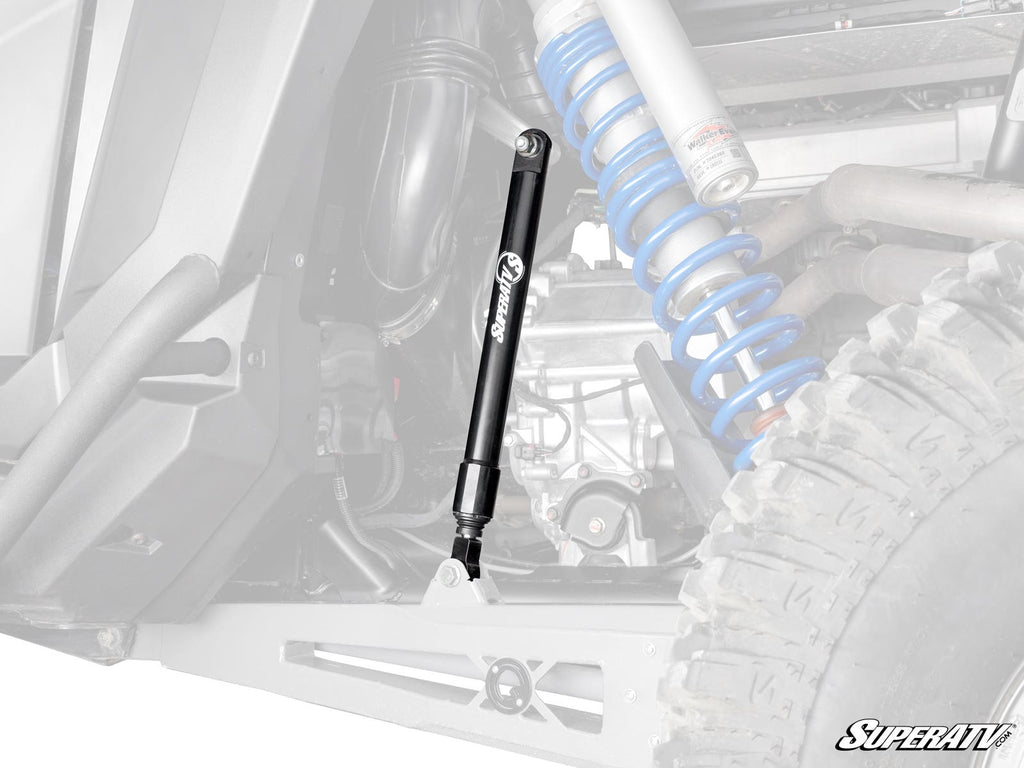 A Polaris RZR Pro R Sway Bar Shock is prominently mounted on an off-road vehicle’s suspension, with coil springs, shocks, and a rugged tire in view. The faded background highlights the sway bar shock. SuperATV logo appears in the corner.