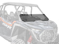 A Polaris RZR Pro S Half Windshield, tinted and mounted with visible hardware, is installed on a black and gray Polaris RZR. The half windshield covers the lower front, with the rest of the side-by-side vehicle blurred in the background.