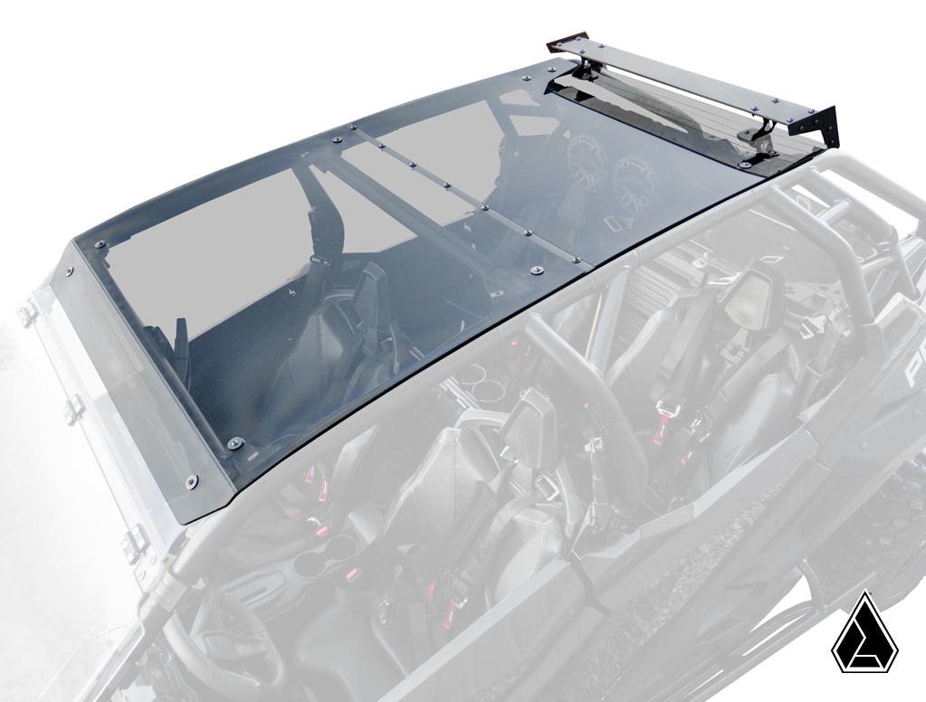 The Assault Industries Polaris RZR PRO XP 4 Tinted Roof is shown mounted on a black off-road vehicle with four bucket seats. The image displays the transparent roof and hardware, with a geometric logo in the bottom right corner.