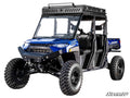 A blue Polaris Ranger XP 1000 Long Travel Kit off-road vehicle with four seats, rugged tires, roof rack, and LED light bar. Features front windshield, side doors for rough terrain, and branding stickers on the sides.