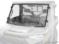 A Polaris Ranger 1000 Vented Full Windshield with black mounting brackets is installed, covering the entire front of a two-seat side-by-side. The SuperATV logo appears at the bottom right, protecting the cabin and dashboard.