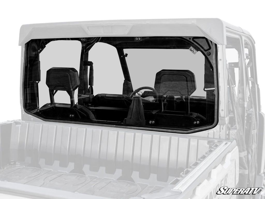 A Polaris Ranger XD 1500 Rear Windshield made of clear polycarbonate is installed on a white utility vehicle, showing the three-seat cab interior, steering wheel, and headrests. The SuperATV logo appears in the lower right corner.