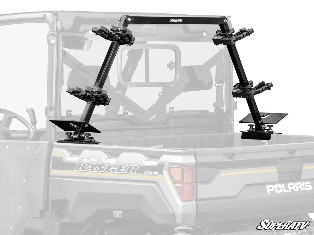 The Polaris Ranger In-Bed Gun Rack is a black metal rack with multiple padded holders, mounted elevated and angled in the cargo bed to securely carry several rifles or shotguns during off-road travel.