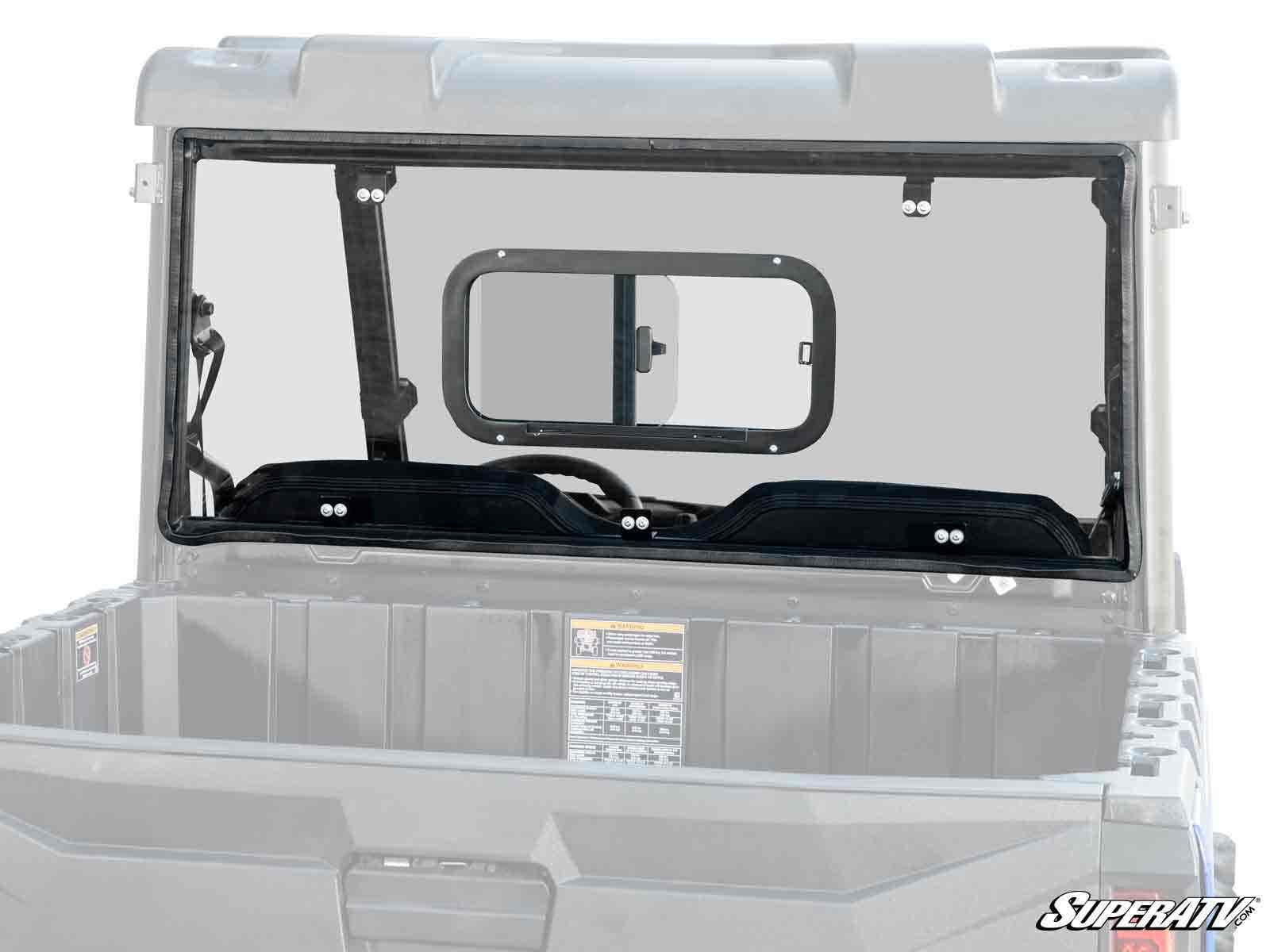 A clear Polaris Ranger Midsize Rear Sliding Windshield with a small rectangular sliding window is installed behind the cab on a gray utility vehicle. The SuperATV logo is shown in the bottom right corner of the image.