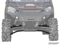 Close-up of a Polaris Ranger 1000 Diesel with High Clearance 1.5 Forward Offset A-Arms, featuring big knobby tires, winch, LED light bars, and heavy-duty suspension under the grill. “SuperATV” logo at bottom right; faded background highlights the front pa