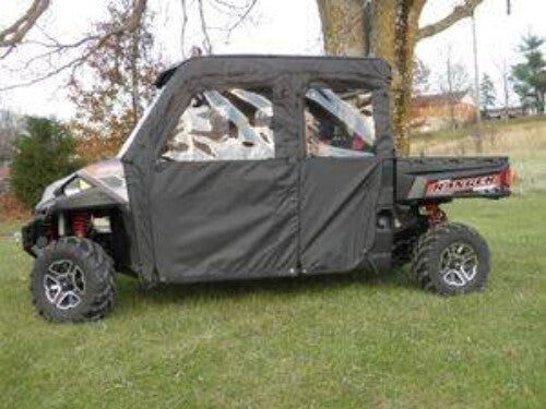 A Polaris Ranger Crew with the Soft Door Kit for all full and mid-size models is parked on grass near trees, featuring fabric door enclosures, rugged tires, a small cargo bed labeled Ranger, and a building in the background.