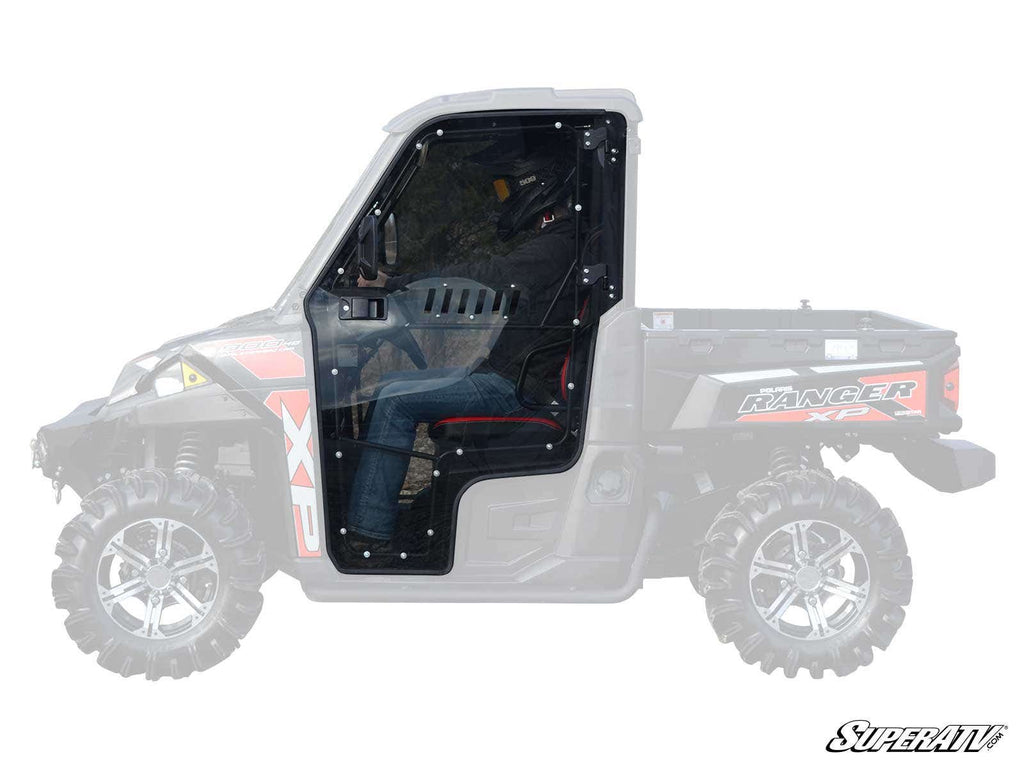 A side view shows Polaris Ranger Cab Enclosure Doors with a clear, black frame installed on a UTV. The rest of the vehicle is faded, highlighting the doors. Rugged tires and Ranger XP/XP logos are visible, with a SuperATV logo at bottom right.