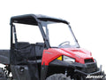 A Polaris Ranger Midsize with a full windshield, black roof, and mesh side doors is shown on a white background. It features rugged tires, two seats, side and front branding, and the SuperATV logo at the bottom right.