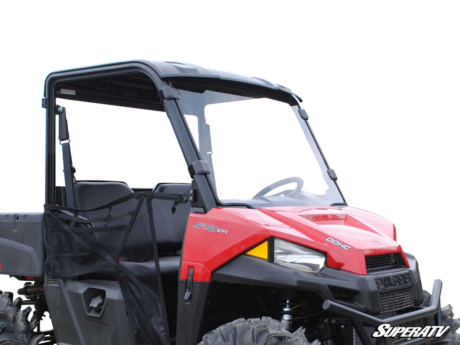 A Polaris Ranger Midsize with a full windshield, black roof, and mesh side doors is shown on a white background. It features rugged tires, two seats, side and front branding, and the SuperATV logo at the bottom right.