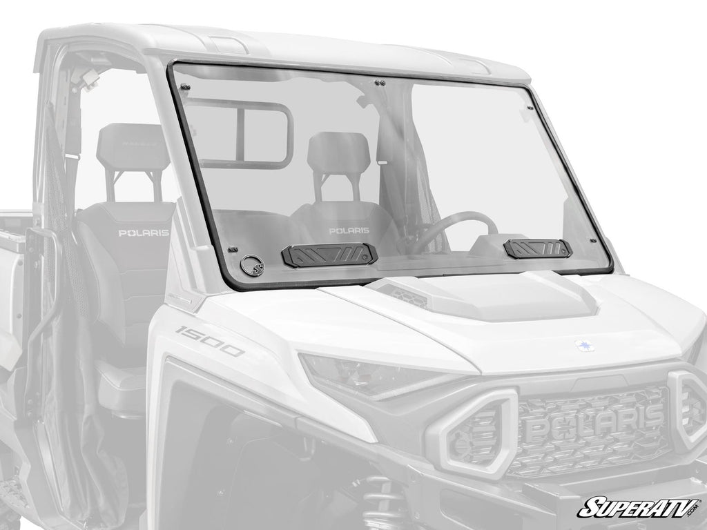 A SuperATV-branded Polaris Ranger XD 1500 Vented Full Windshield, made of clear polycarbonate with two black vents, is mounted on a white Polaris utility vehicle, covering the front cabin with seats and steering wheel visible inside.