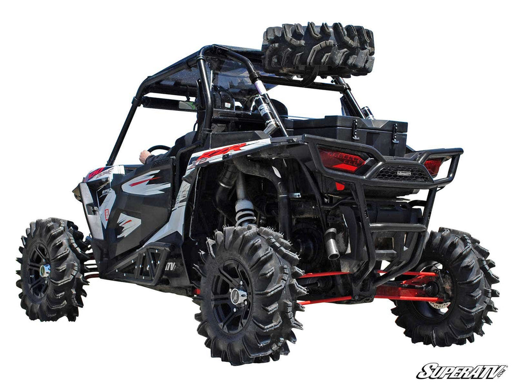 A Polaris RZR XP Turbo equipped with a black and red spare tire carrier, large rugged tires, roll cage, and extra spare tires mounted on the rear cargo rack, viewed from the back left side against a white background.