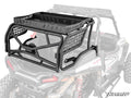 A Polaris RZR XP 1000 Outfitter Sport Bed Rack, made of heavy-duty black tubular steel with mesh sides and a solid tray with side holes, is shown mounted on the back of an off-road vehicle. The photo is grayscale except for the highlighted rack.