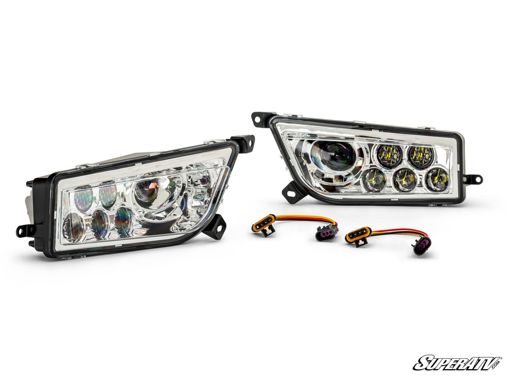 Two Up & Running Polaris RZR Replacement Headlight Assemblies with black trim are shown side by side, along with two wiring harnesses. The SuperATV logo is in the bottom right corner against a white background.