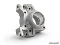 The Up & Running Polaris RZR RS1 Rear Knuckle is a machined silver metal part with multiple mounting holes, a large circular opening, precise edges, and varying textures. It sits on a white background with the SuperATV logo in the bottom right corner.