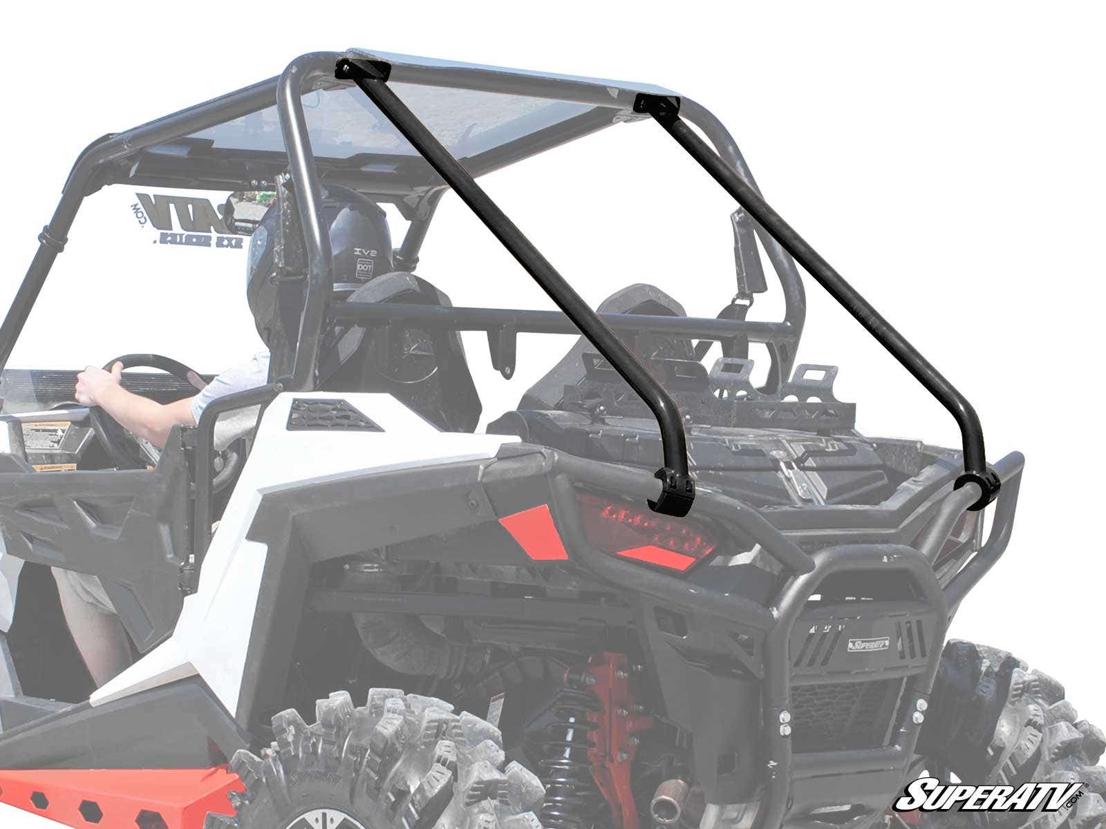 A close-up of a Polaris RZR S 1000 with rear cage support, showing diagonal bars, black seats, and a helmeted driver. The white background highlights the vehicle’s rear and the SuperATV logo in the bottom right corner.