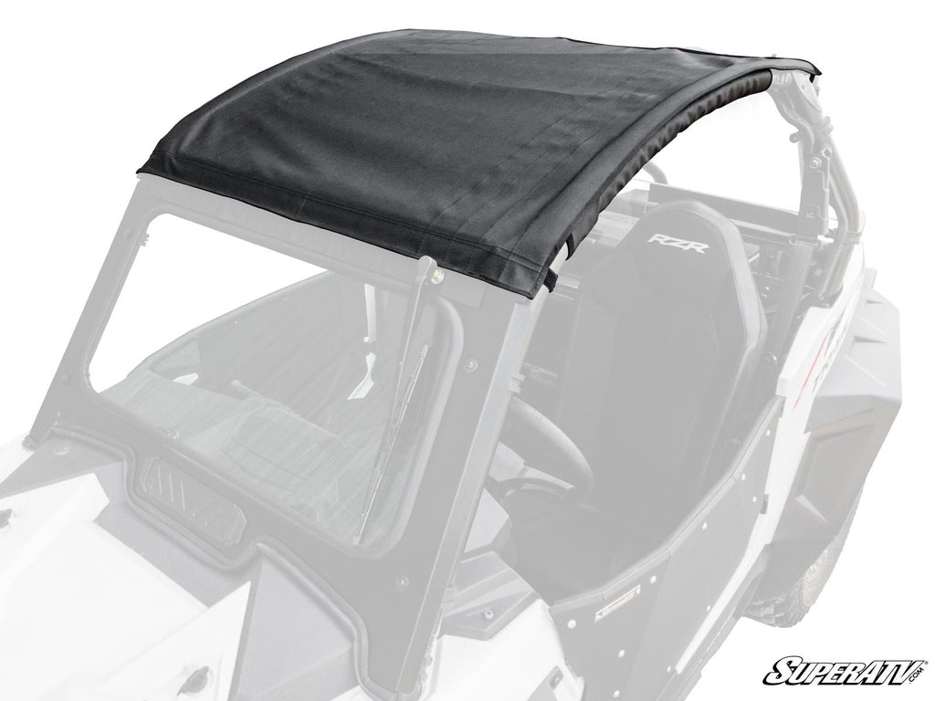 A Polaris RZR Trail S 1000 Primal Soft Top Roof in black is installed on a white off-road utility vehicle, shading the front seats and fitting snugly over the open cabin. The SuperATV logo appears in the image’s bottom right corner.