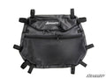 The Polaris RZR Overhead Storage Bag is black with the SuperATV logo, features a main zippered compartment, a smaller front zippered pocket, a mesh front pocket, and multiple adjustable straps for secure attachment. Displayed on a white background.