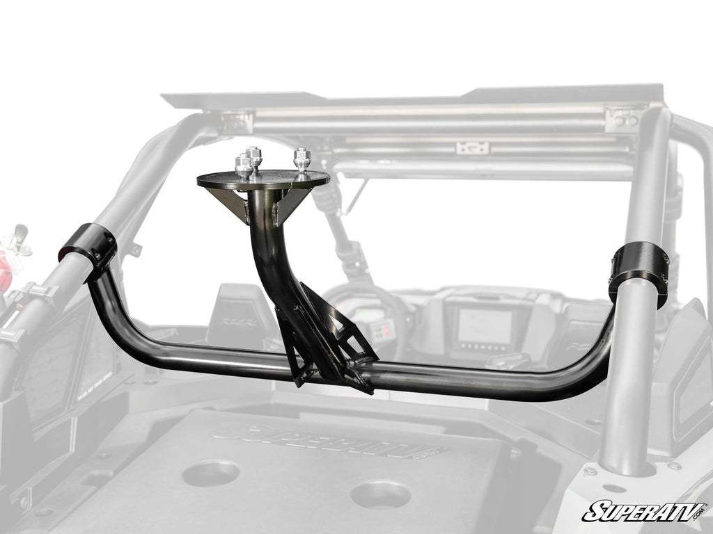 A close-up of a Polaris RZR Pro S Spare Tire Carrier installed inside a side-by-side UTV. The carrier is mounted on the roll cage with bolts and clamps, while the UTV’s dashboard and seats are visible in the background.