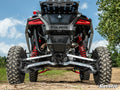 Rear view of a black Polaris off-road vehicle with Polaris RZR Turbo R Trailing Arms, large rugged tires, red shocks, and “Polaris” branding on a dirt trail. Green grass and trees under a blue sky; SuperATV logo in the corner.