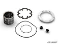 The Polaris Billet Front Differential Rebuild Kit includes a cylindrical roller bearing, two black rubber O-rings, a round metal retaining plate, a notched metal ring, and two small black threaded plugs arranged on a white background.