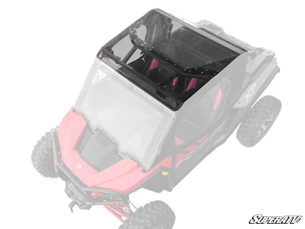 A top-down view of a red off-road vehicle with a Polaris RZR XP Tinted Roof installed. The desaturated vehicle, except the black-tinted roof, highlights its angular design. The “SuperATV” logo is visible in the bottom right corner.