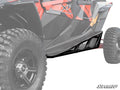 Close-up of the front left side of a red and black off-road vehicle, showcasing its rugged tire and a Polaris RZR XP 4 1000 Nerf Bar under the door. The SuperATV logo appears in the lower right on a faded white background.