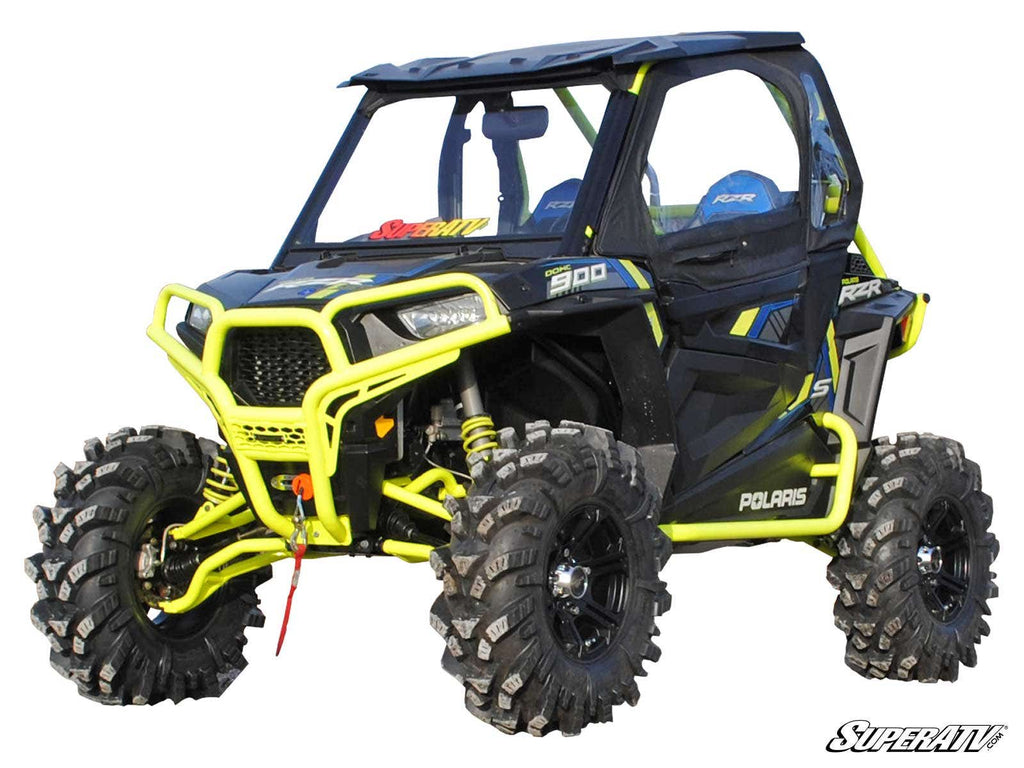 A Polaris RZR S 900 ATV in black and neon yellow with rugged tires, roll cage, two blue seats, front winch, and custom decals is shown parked on white. The SuperATV logo appears bottom right. Features a 3 Lift Kit upgrade.