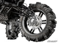 Close-up of a Polaris Scrambler 8 Portal Gear Lift showing the off-road suspension, large deep-tread mud tires, wheel’s disc brake, rugged control arms, and shock absorber. “SuperATV” branding is visible in the bottom right corner.