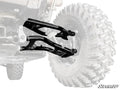A black Polaris Xpedition Atlas Pro Rear A-Arm is shown over a faded off-road vehicle tire and undercarriage, with the SuperATV logo in the lower right. The image showcases the rugged design and precise fit of the A-Arm.