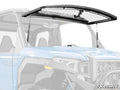 A blue Polaris Xpedition equipped with a Scratch-Resistant Flip Windshield, partially open with metal struts on both sides. The cab interior and two seats are visible. The SuperATV logo appears in the lower right corner.