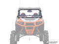 The image displays the front view of a Polaris General equipped with the Flip Down Windshield, large mud tires, and a winch. The windshield area is highlighted while the background and parts of the vehicle are faded. SuperATV logo appears bottom right.