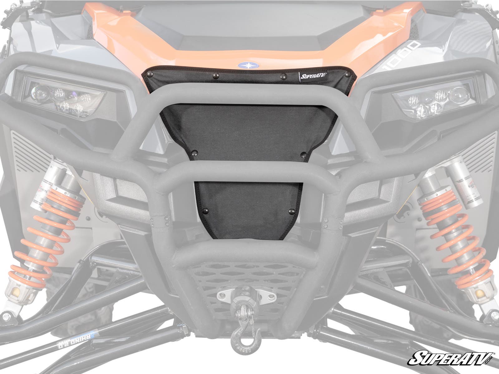 Close-up of a Polaris General Grille Cover featuring a black mesh design, orange suspension springs, sturdy metal bumper, headlights, and a winch hook at the bottom center. The SuperATV logo appears in the lower right corner.