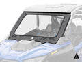 A close-up of the Assault Industries Polaris RZR Pro R 4 Glass Windshield, a clear, rectangular windshield with a black frame on a blue off-road vehicle. The shield covers the front seats and features a geometric logo in the bottom right corner.