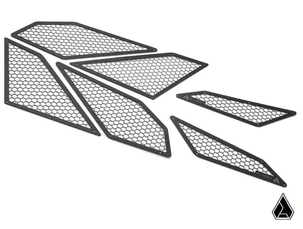 Six black, thin, geometric mesh panels with a honeycomb pattern are arranged on a white background. Each is a unique irregular quadrilateral in shape and size. The Assault Industries Polaris RZR Pro R Intake Cover logo appears at the bottom right.